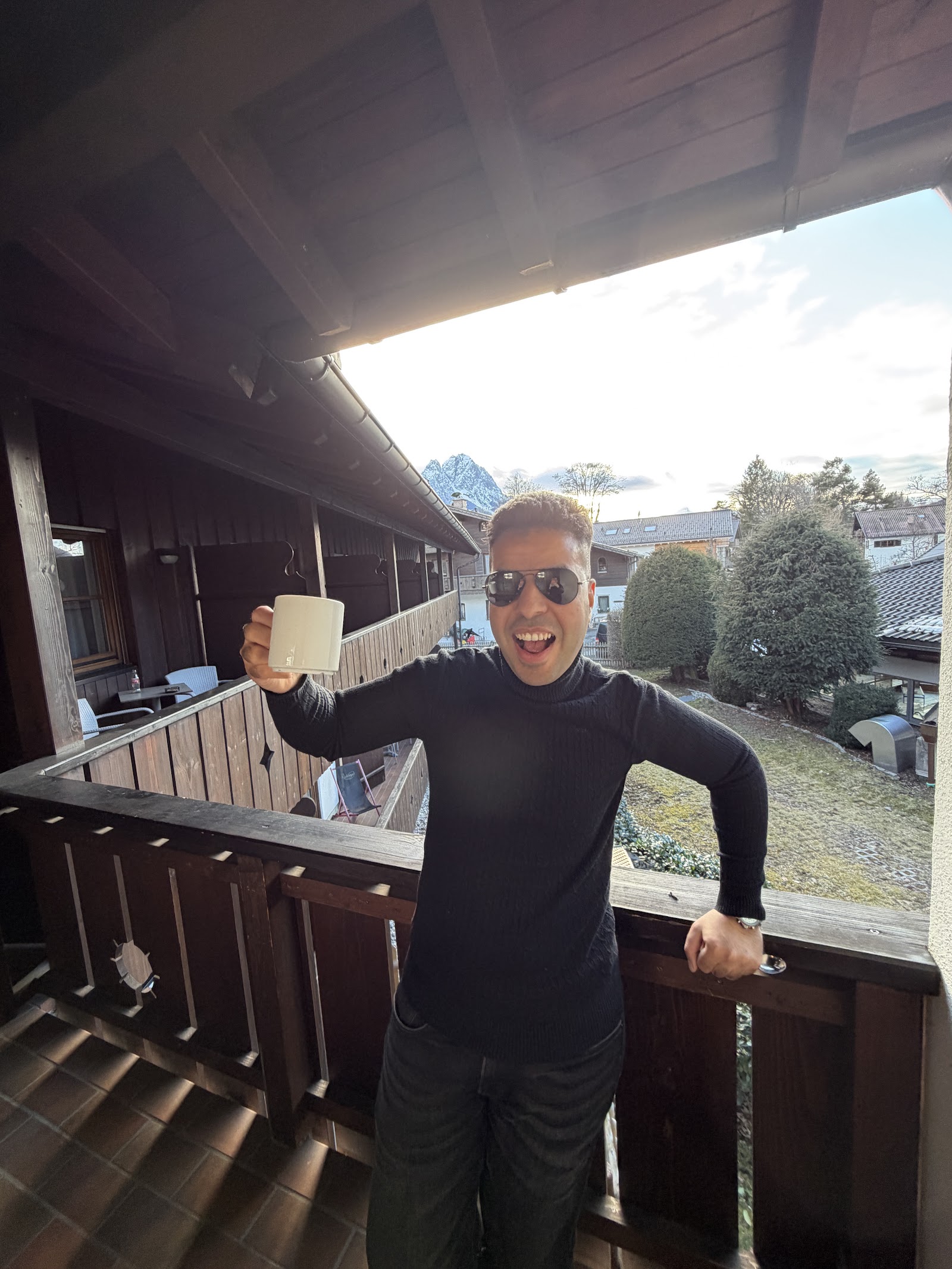 Ahmed enjoying a drink on a balcony.