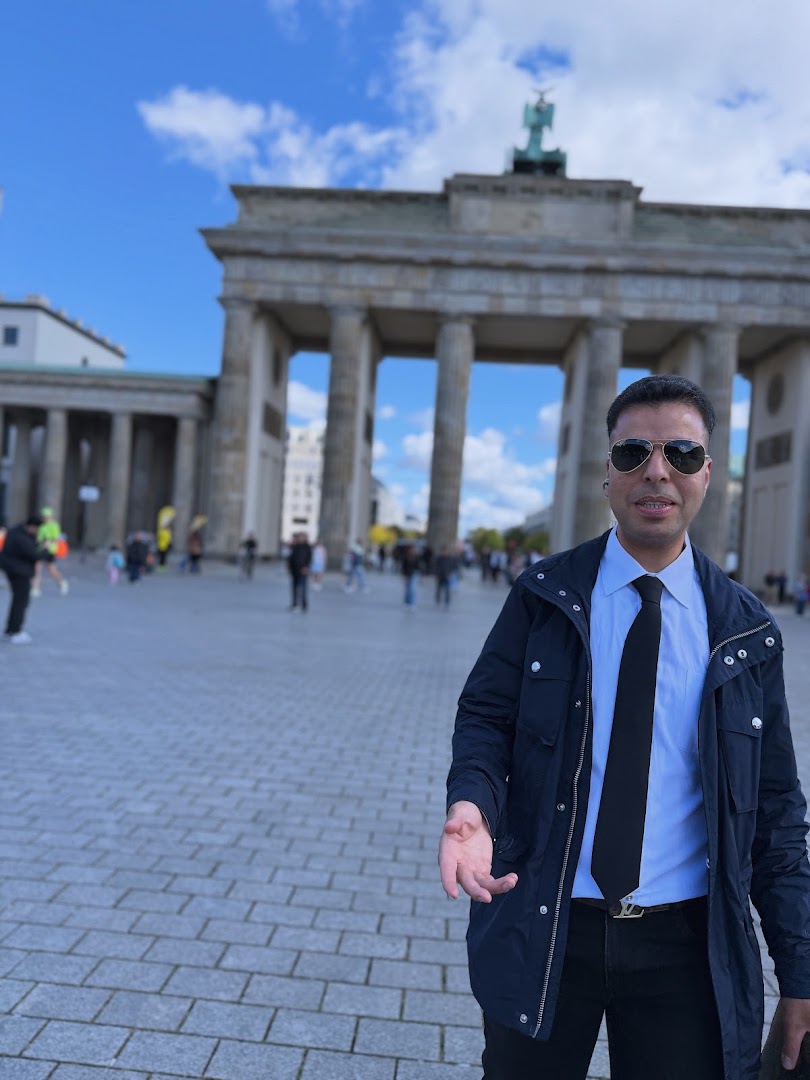 Ahmed Kamel wearing a suit and sunglasses at the Brandenburg Gate